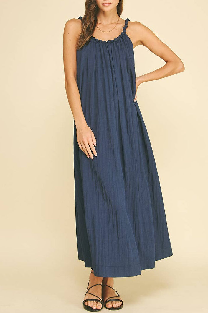 Woman wearing a blue dress against a beige background