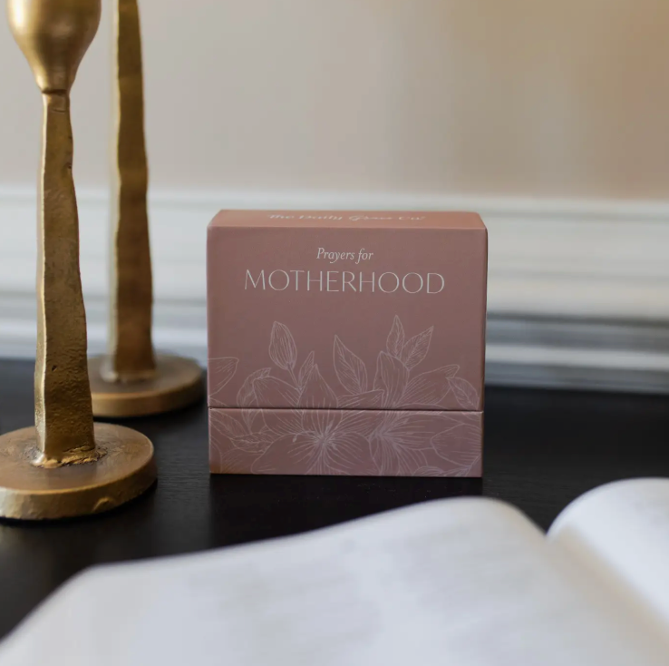 Box of prayer cards titled 'Prayers for Motherhood' on a surface with decorative elements