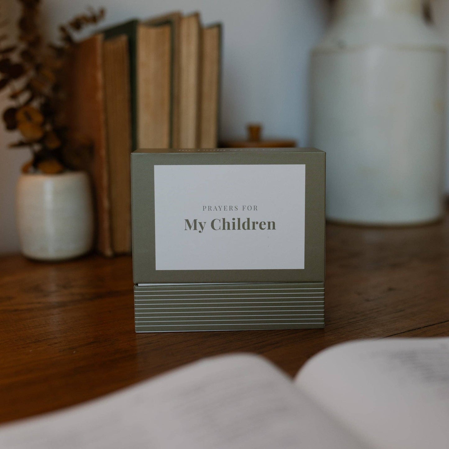 Box of prayer cards titled 'Prayers for My Children' on a wooden surface with decorative items in the background.