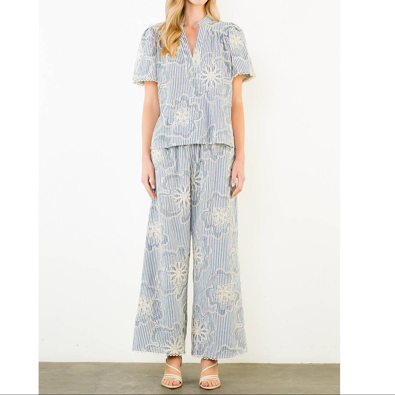 Woman wearing a blue and white floral outfit on a white background