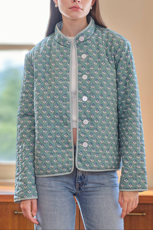 Woman wearing a patterned green jacket indoors